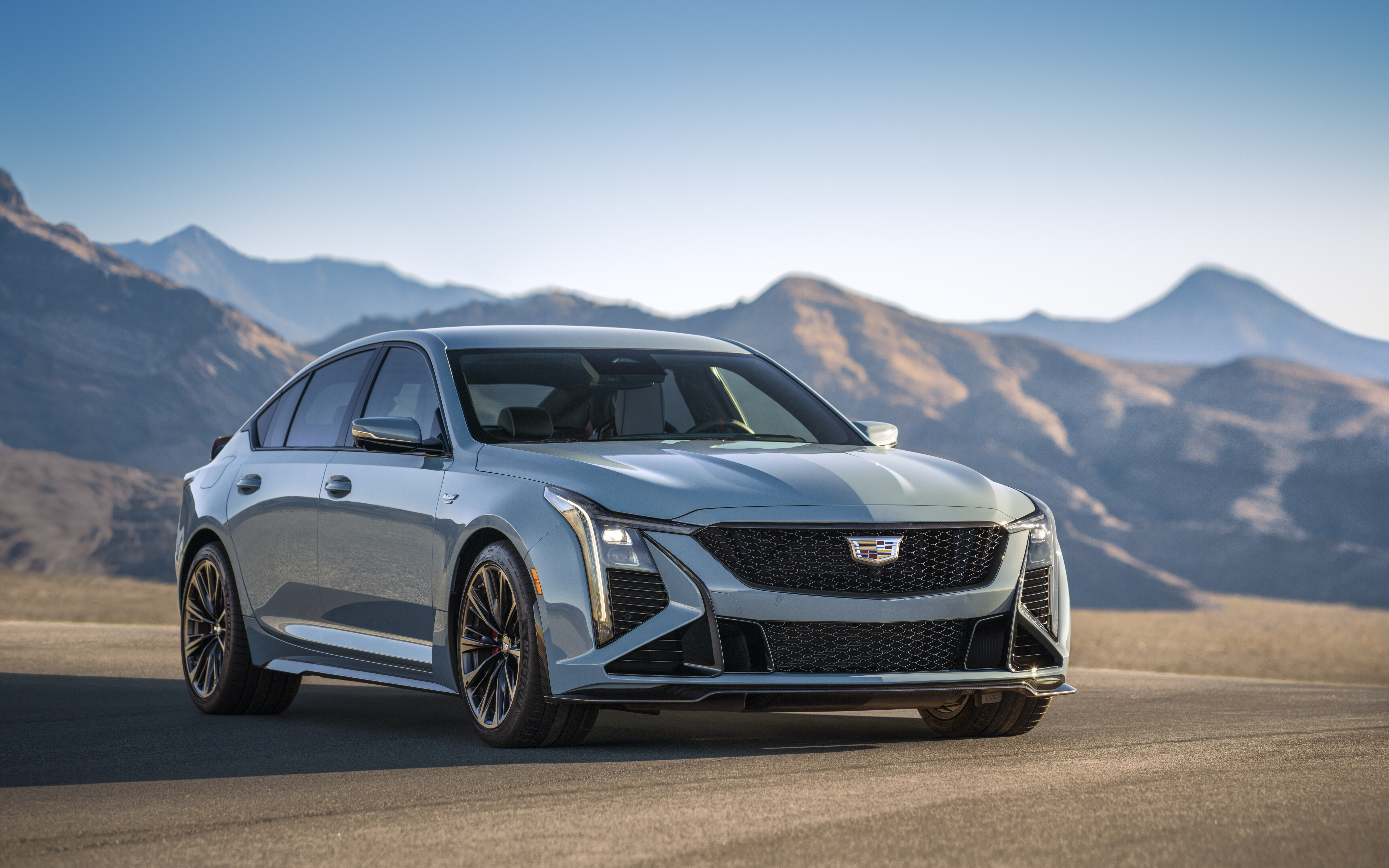 Uma imagem detalhada de um Cadillac CT5-V Blackwing, um sedan, que destaca a sua moderna grelha, os faróis e o design luxuoso do automóvel.