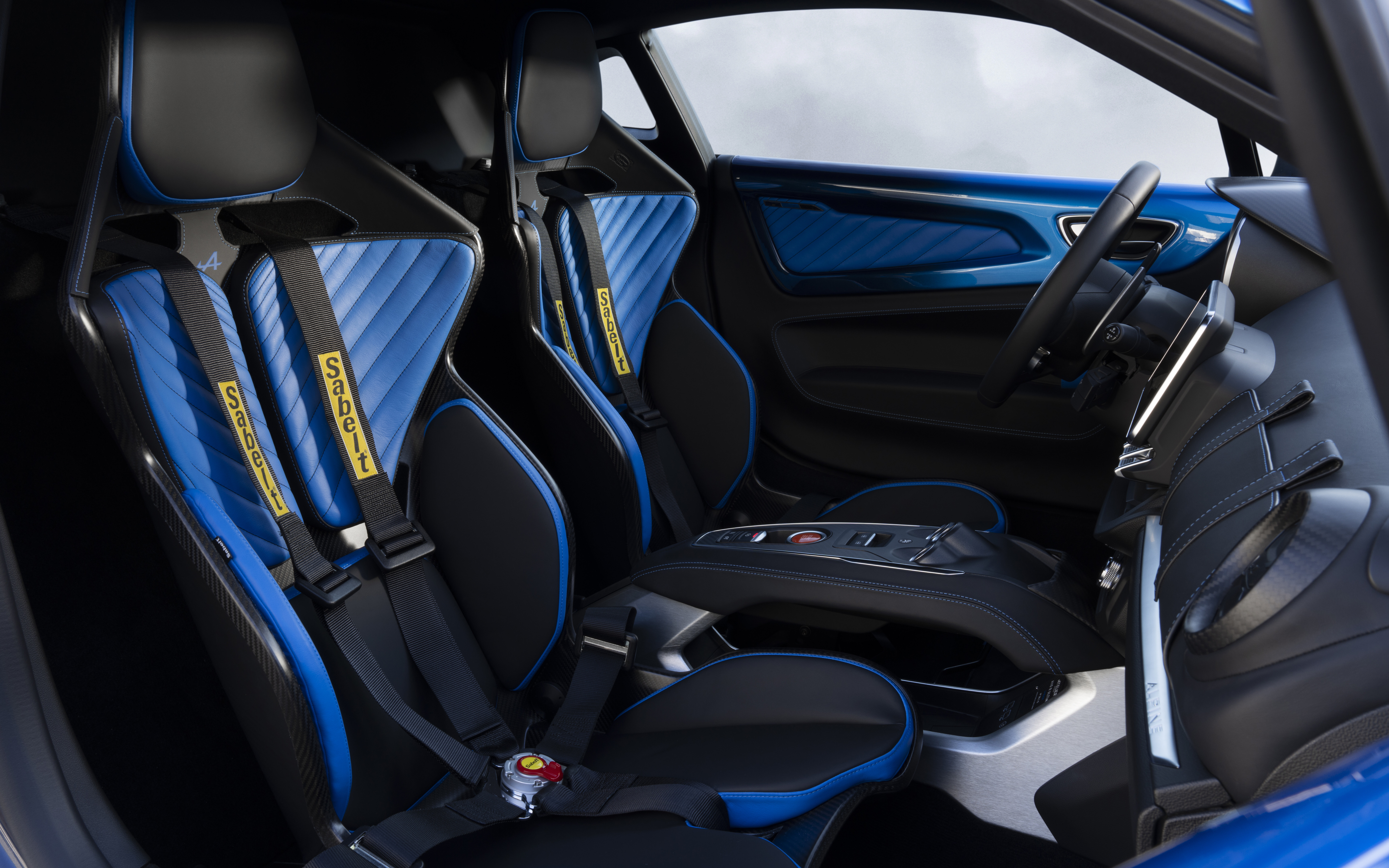 Vista detalhada do painel de instrumentos e dos detalhes interiores do habitáculo de um Alpine A110 R Ultime, um carro desportivo.