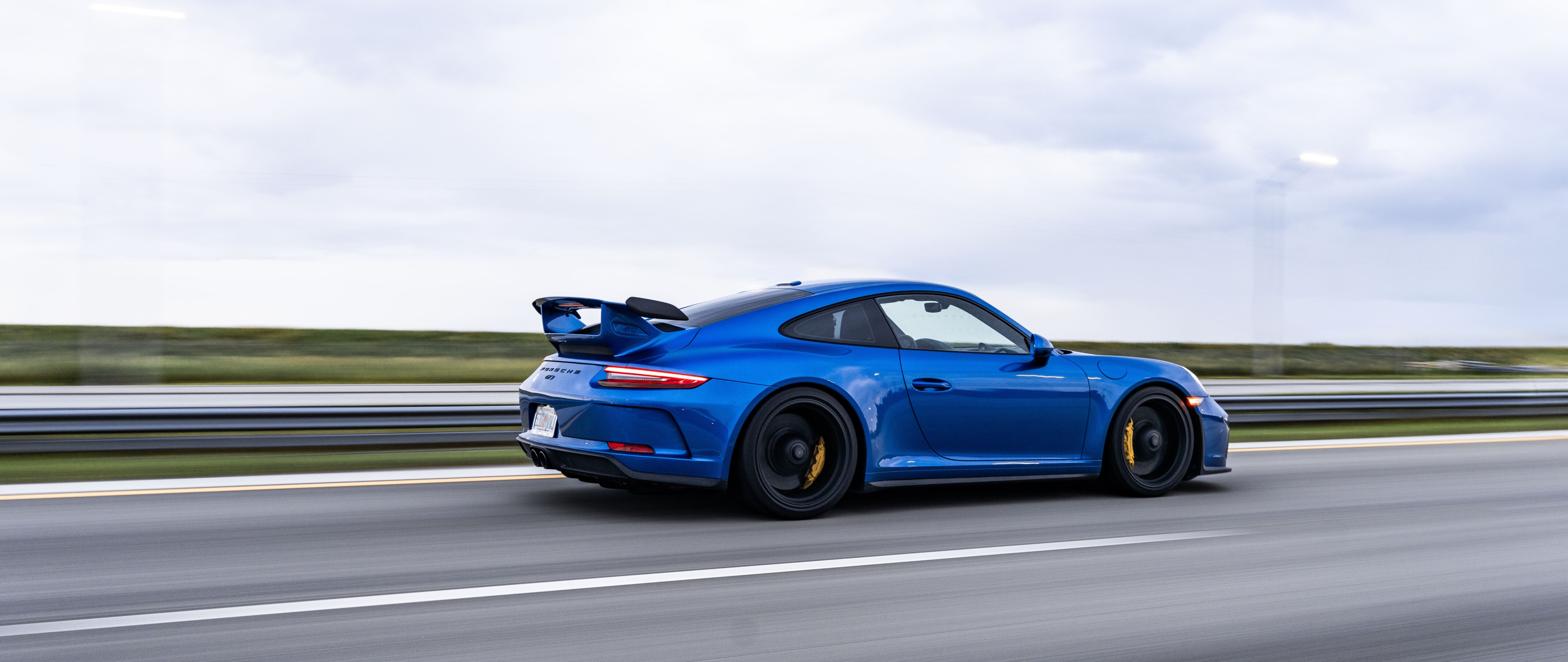Um carro esportivo Porsche GT3 RS de alto desempenho, com elementos aerodinâmicos inspirados em carros de corrida.