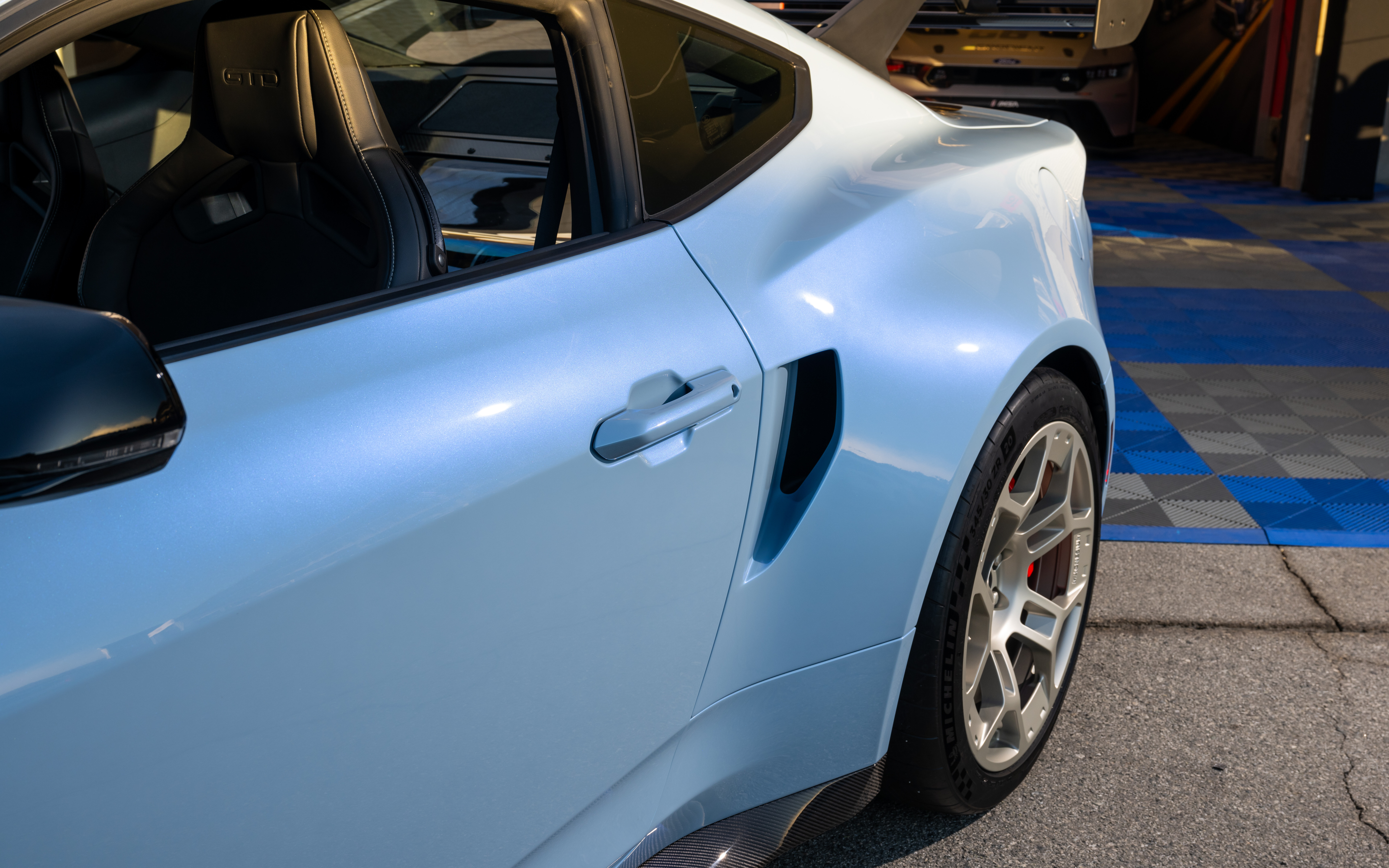 Uma imagem detalhada de um Ford Mustang GTD, destacando o seu design aerodinâmico e agressivo, bem como o seu kit de carroçaria alargada.