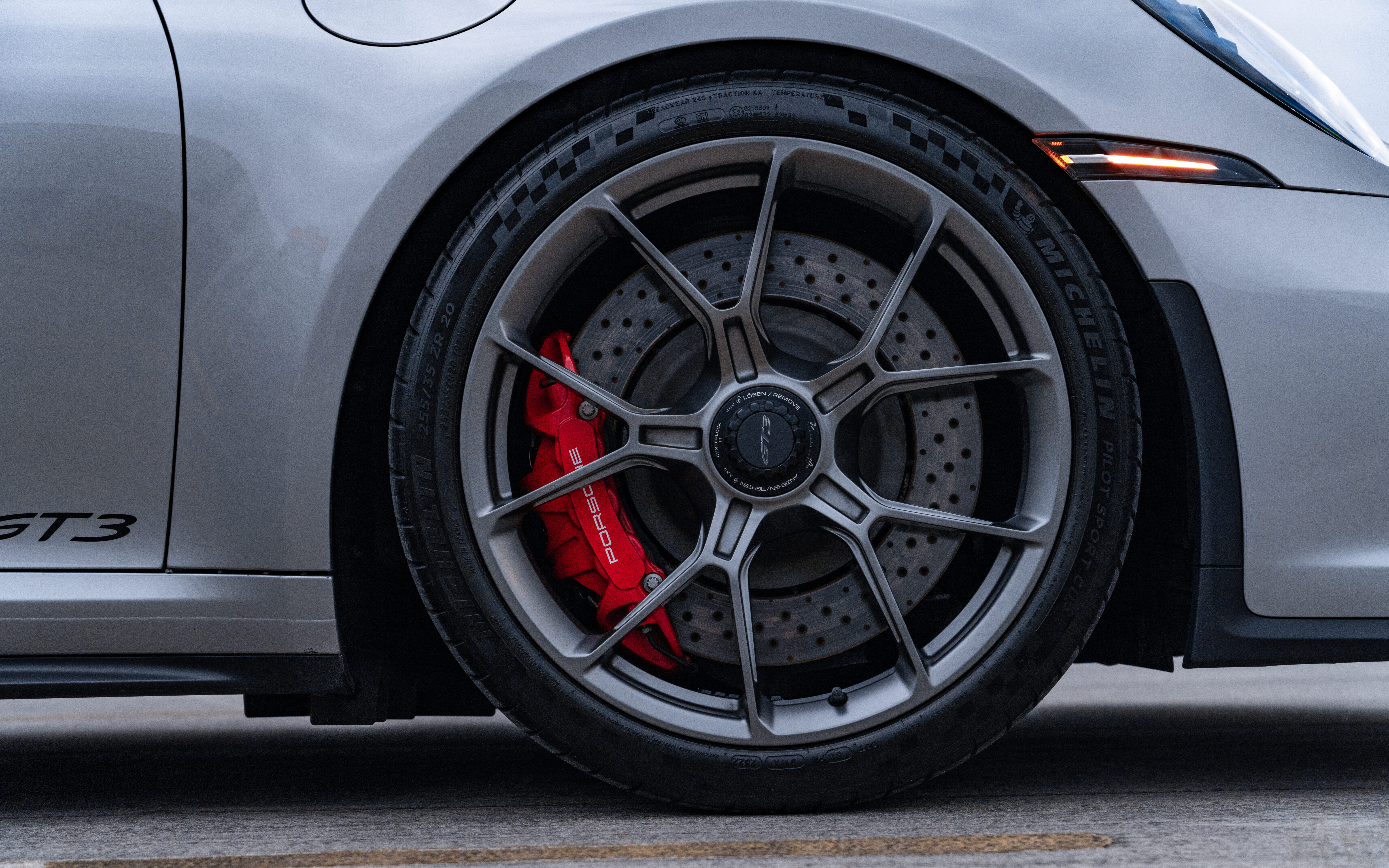 Um carro esportivo Porsche GT3 RS de alto desempenho, com carroceria aerodinâmica e um característico spoiler traseiro.