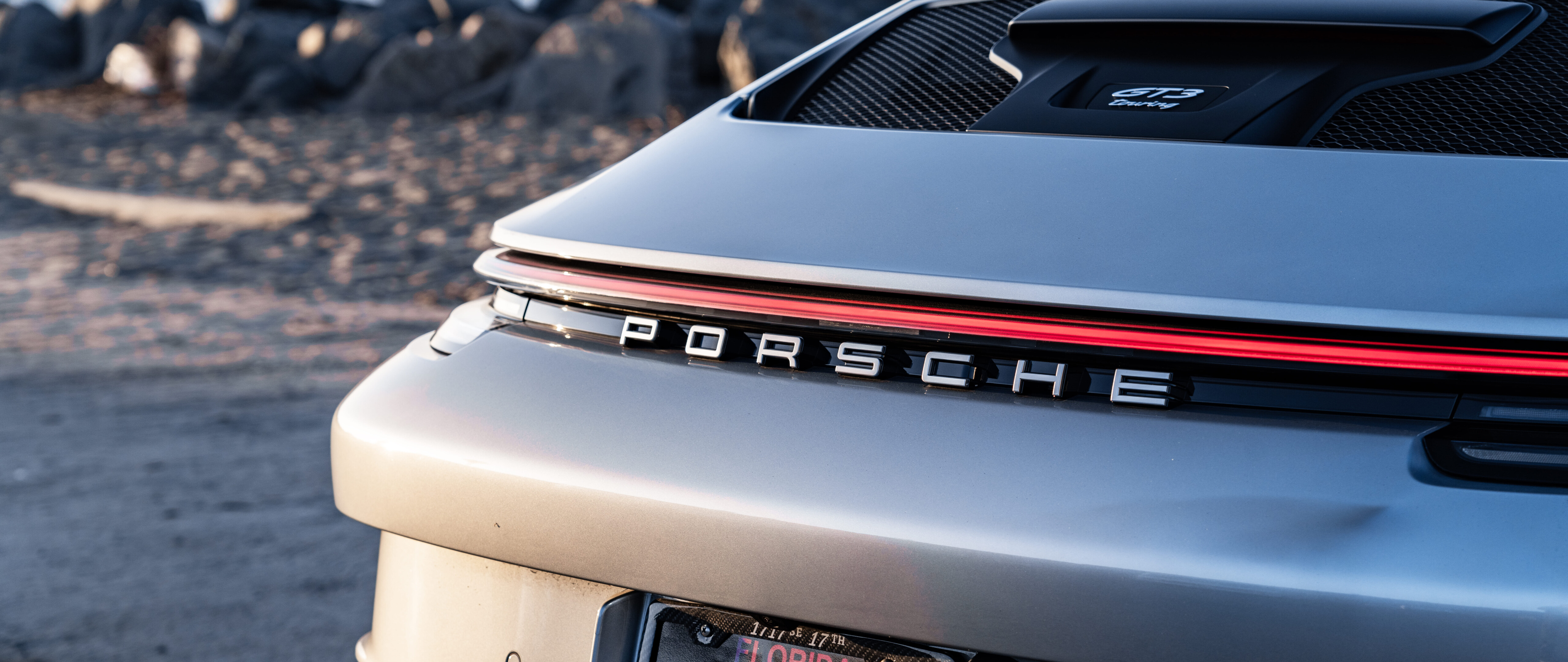 Um carro esportivo Porsche GT3 RS de alto desempenho, com um design aerodinâmico arrojado e uma silhueta elegante, inspirada nos carros de corrida.