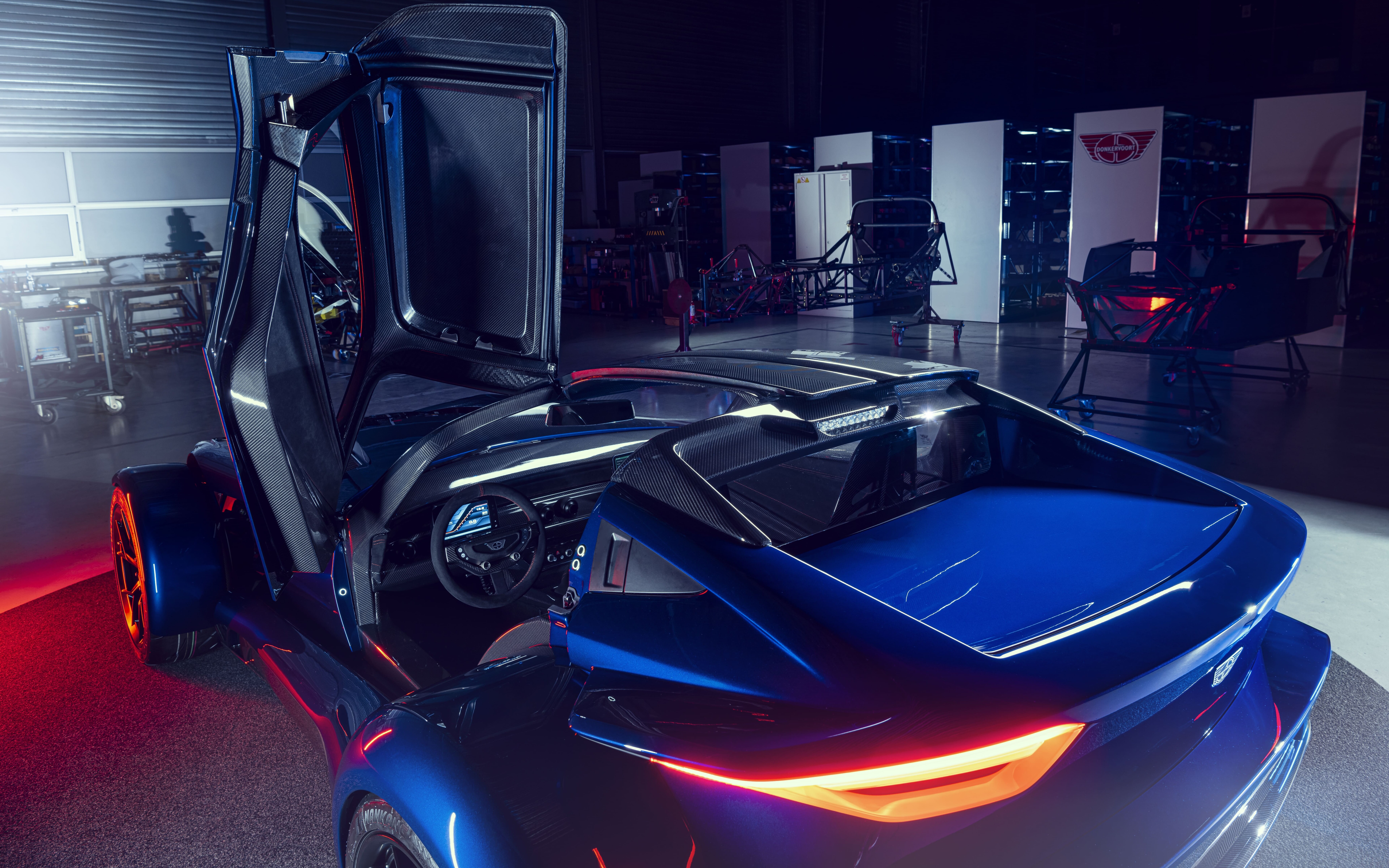 Um elegante carro desportivo prateado, com acabamento metálico, que reflete a luz suave do estúdio contra um fundo escuro.