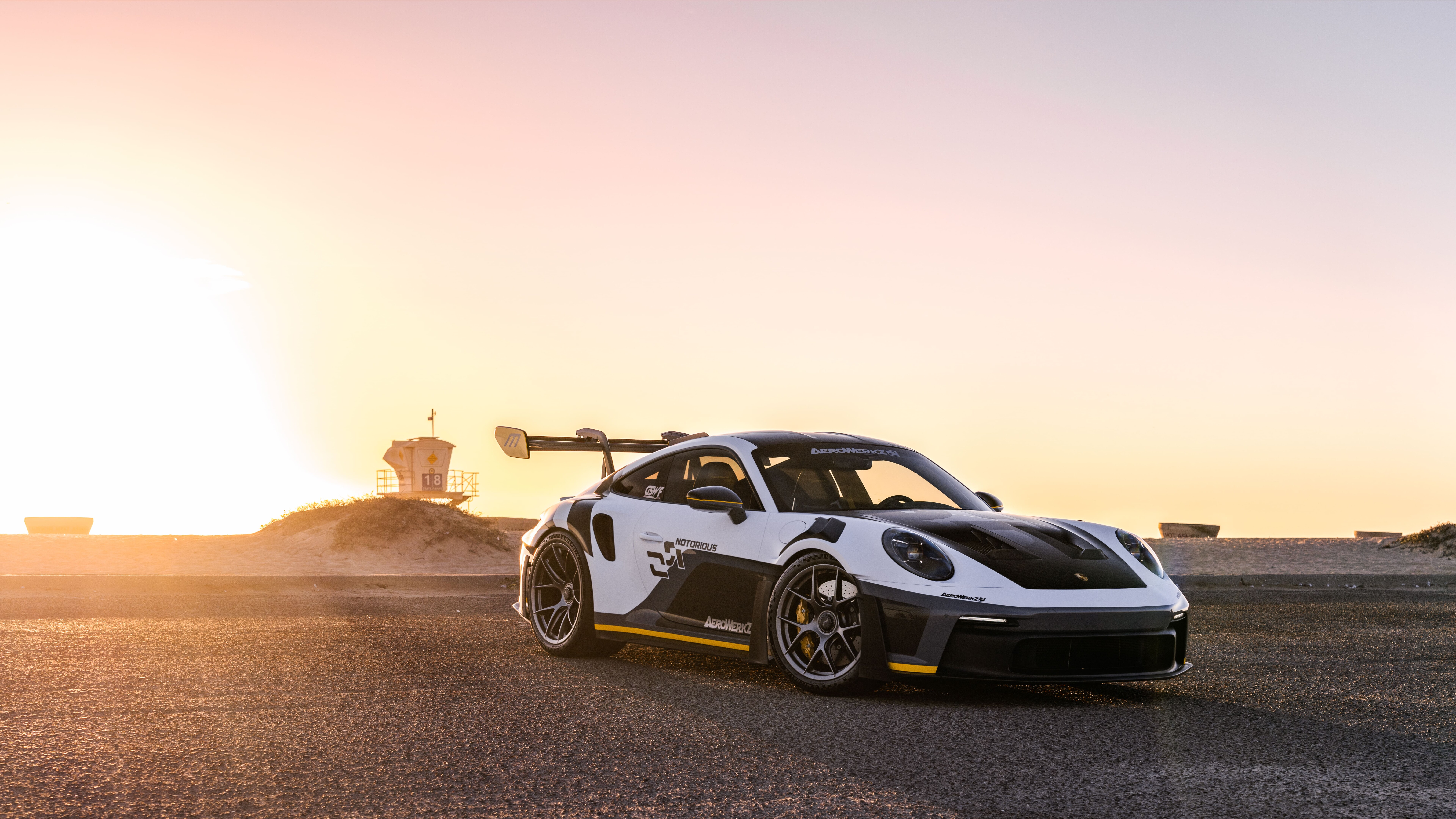 Um carro esportivo Porsche GT3 RS de alto desempenho, com uma carroceria aerodinâmica agressiva e um grande spoiler traseiro.